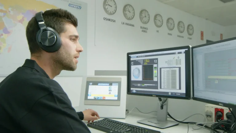Commercial support specialist assisting customers remotely using Girbau equipment and monitoring software.