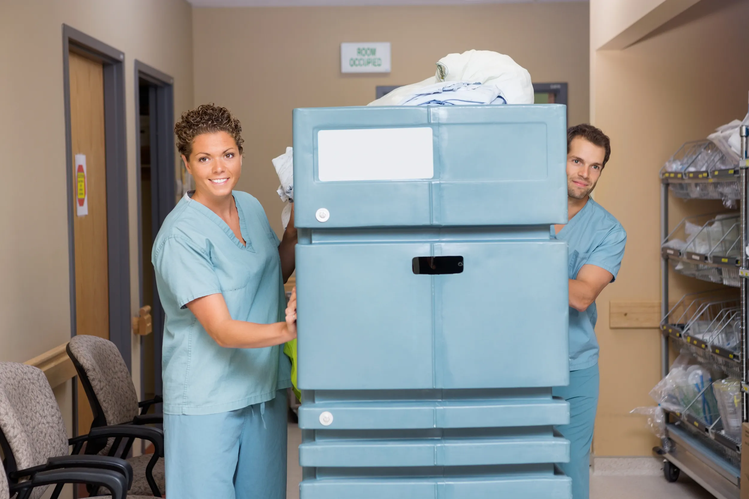 Healthcare laundry staff with laundry trolley