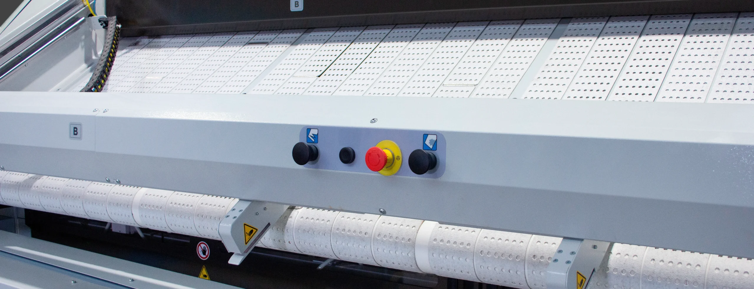 Compact industrial ironing machine with heated cylinder and feeding system, designed for efficient flatwork finishing in professional laundry operations.
