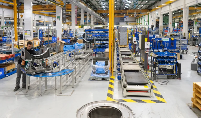 Industrial workspace with a technician operating machinery, illustrating Girbau’s commitment to a safe and healthy work environment.
