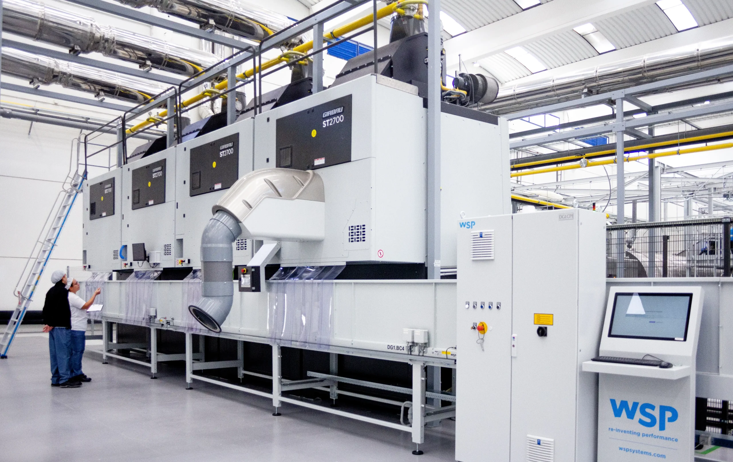 Industrial Girbau laundry equipment in a production facility, illustrating engineering, innovation and sustainable solutions for commercial and industrial laundry operations.