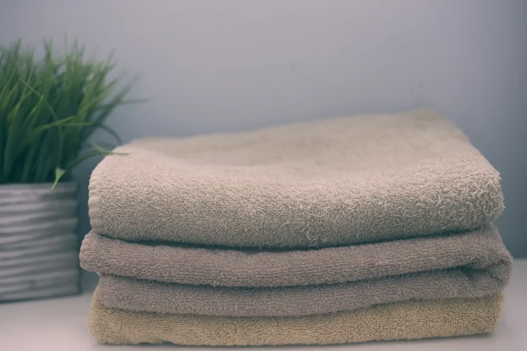 Soft folded towels next to a plant representing My Girbau, the customer portal for registering machines and accessing manuals, technical documentation and online services.