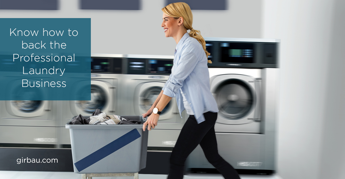 Woman carrying a trolley across a laundry facility