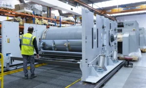 Técnico de Girbau inspeccionando la estructura y el tambor de una calandra industrial PC durante su fabricación, mostrando la calidad certificada y la fiabilidad del equipo.