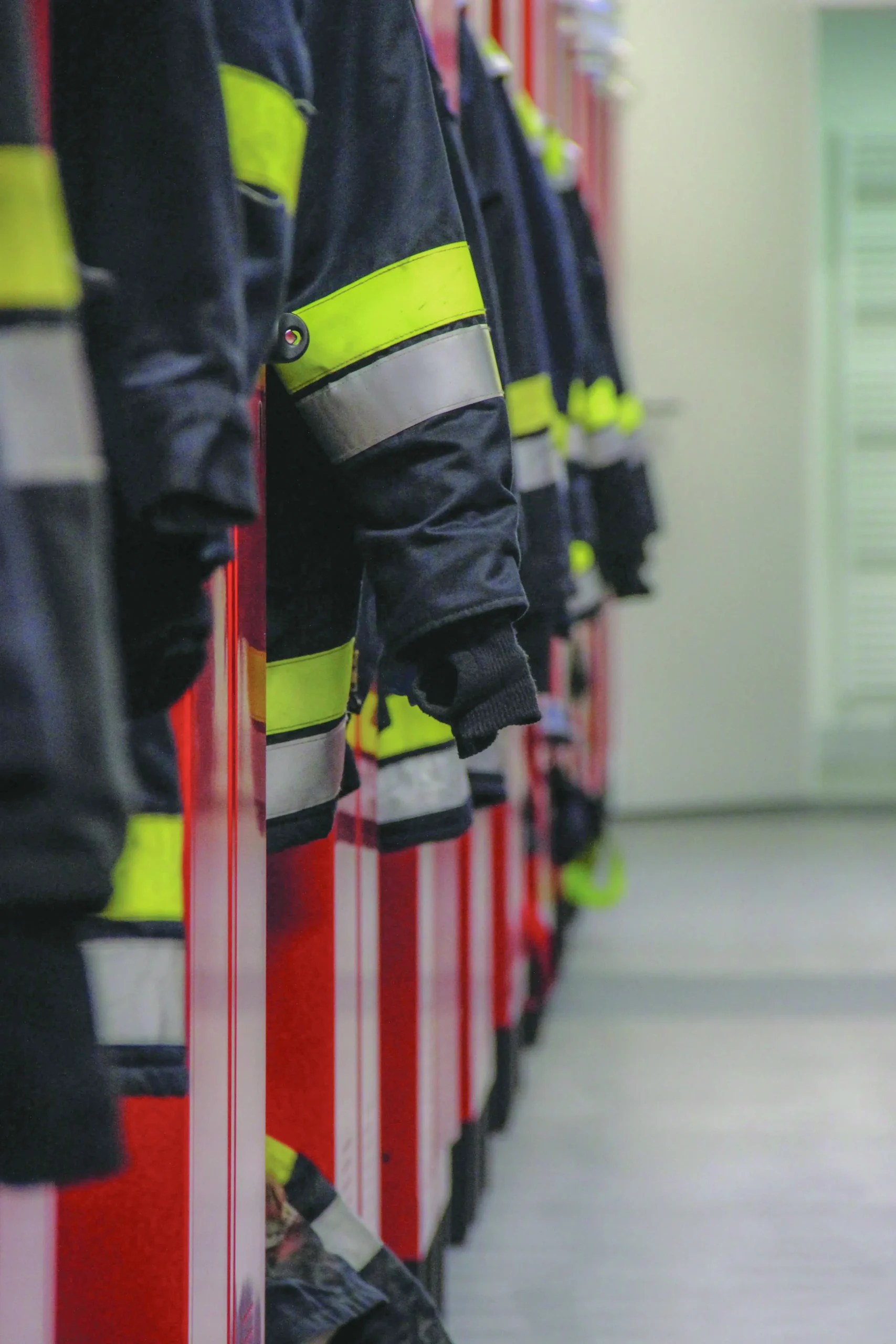 Uniformes de bombeiros armazenados em armários, representando necessidades de lavanderia para serviços de emergência e instalações especializadas.