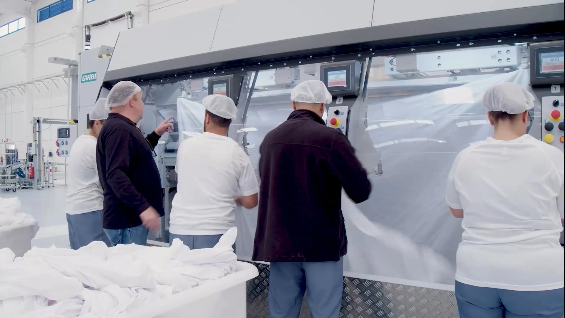 Girbau team analyzing industrial laundry equipment to identify inefficiencies and improve workflow performance.