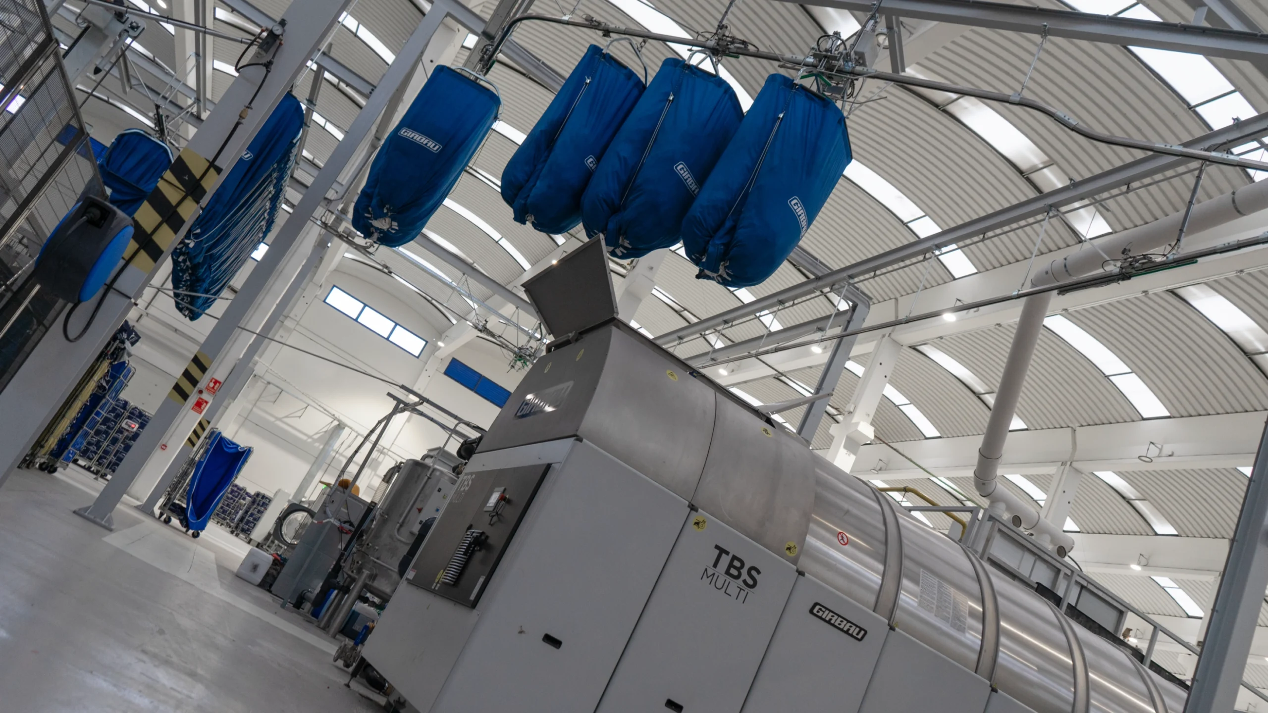 Overhead loading system for a washer tunnel