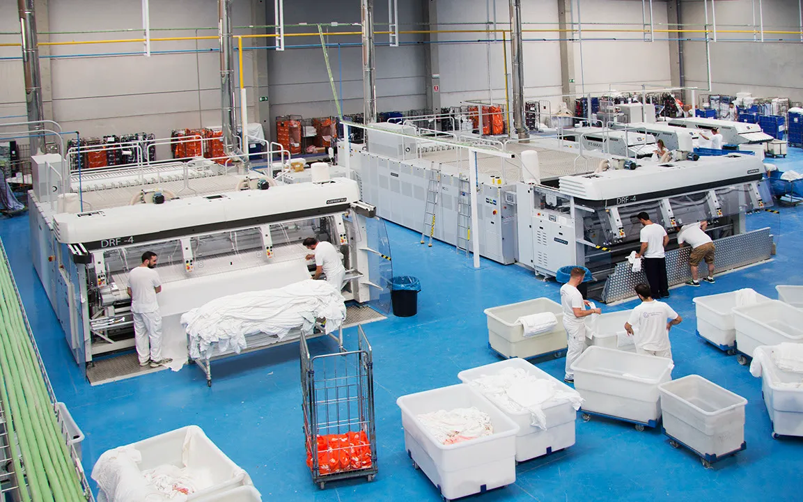 General view of Lavandería Industrial Medina laundry plant with staff and equipment in operation.